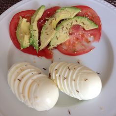 sliced tomatoes and avocado on a white plate