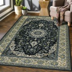 a living room area with a couch, chair and large rug on the floor in front of a window