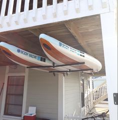 two kayaks are attached to the roof of a house