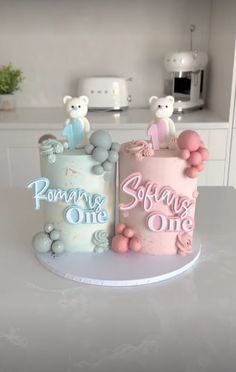 two cakes decorated with teddy bears and balloons on a table in a kitchen, one is for someone's first birthday