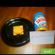 a black plate topped with butter next to a jar of skippy pretzels