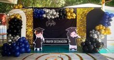 graduation decorations and balloons are set up in front of a backdrop for an event at the park