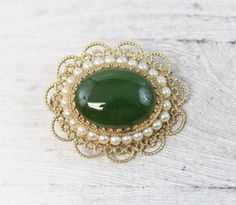 N6386Mid Century Asian 14K Yellow Gold Jade Pearl Pendant Brooch Filigree Pretty LuxuryNATURAL GREEN JADE CABOCHON WITH A ROW OF CULTURED PEARLS AROUND. FILIGREE DESIGN. AMAZING PENDANT / BROOCH PIN WONDERFUL HIGHEST QUALITY. VERY WELL MADE. JUST PART OF MY MOST RECENT ESTATE FINDS! FOLLOW ME TO SEE THEM ALL! Brand: AsianMetal Purity: 14kMetal: 14K Yellow GoldMaterial: Jade PearlForm: Pendant Brooch Filigree Pretty LuxurySize :1 1/4 x 1 3/8"Age: Mid CenturyWeight (Grams): 10.1IT IS IN EXCELLENT Pendant Brooch, Jasper Ring, Filigree Design, Red Jasper, Green Jade, Star Pendant, Cultured Pearls, Pearl Pendant, Gold Material