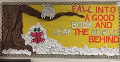 a bulletin board with an owl reading a book and the words fall into a good book and leaf the world behind it