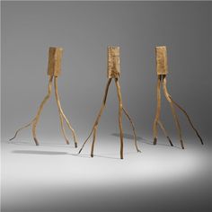 three wooden sticks are arranged in the shape of people's legs, with one standing up