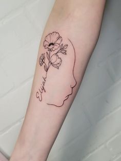 a woman's arm with a flower in the shape of a head and name written on it