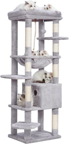 three kittens are laying on top of a cat scratching tower that is grey and white