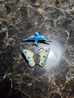 This is a lot of 2 vintage 1940s era Sterling Silver enamel brooches. One is a blue bird Brooch with enamel on both sides and the other is a butterfly that is missing some enamel in the center as shown. Both brooches sold together not separate. In okay condition. Sold as is. Antique Enamel Brooches As Gift, Vintage Enamel Brooches For Evening, 1940s Brooch, Vintage Enamel Evening Brooches, Vintage Handmade Butterfly Brooch, Enamel Brooch, Bird Brooch, Butterfly Brooch, Silver Enamel