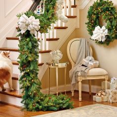 christmas wreaths on the banister and stairs decorated with white poinsettias