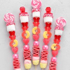 candy lollipops and marshmallows are arranged in the shape of hearts