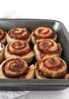 cinnamon rolls in a baking pan on a towel