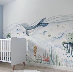 a baby's room with an ocean themed wall mural