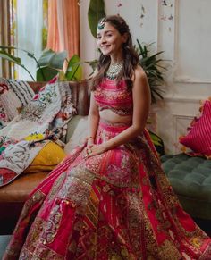 a woman in a red and gold outfit sitting on a couch