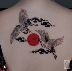 the back of a woman's neck with two birds flying over it and an orange sun