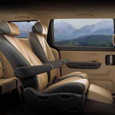 the interior of a vehicle with leather seats and mountains in the backgrouund