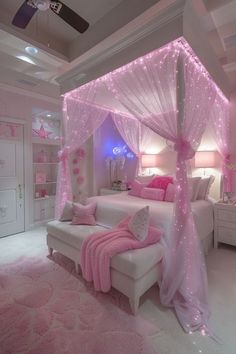 a bedroom decorated in pink and white with lights on the ceiling, bed canopy and pillows