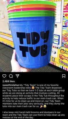 a person holding up a blue bucket with the words tidy tub written in black on it