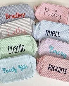 six personalized towels in different colors and designs on a white surface with the names of each