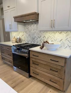 a kitchen counter with a bowl on top of the stove in front of cabinets and drawers