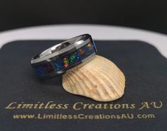 This beautifully handcrafted ring uses a variety of chunks of the highest quality crushed synthetic opals in a tungsten carbide comfort core ring band on a backdrop of a mix of pearlescent powders, giving an exquisite look.  The main colour is a vibrant peacock blue, with secondary hints of green and light blue depending on how the light hits the stones. This was not made using cheap opal tape, but actual crushed synthetic opal stones meticulously placed by hand to ensure a beautiful and natural Blue Crush, Ring Shapes, Wolfram, Synthetic Opal, Opal Color, Peacock Blue, Tungsten Carbide, Handcrafted Rings, Tungsten Ring