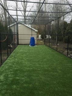 the inside of a fenced in backyard with artificial grass