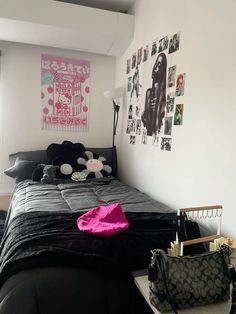 a black and white bedroom with pictures on the wall above the bed, along with a purse