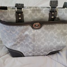 Gray Coach Shoulder Purse. The Purse Has Been Used But Has Original Tag. The Purse Has Several Great Pockets. One Pocket In The Front With A Silver Twist Clasp. There Is A Slip In Pocket On The Back. There Is A Zipper On The Top As Well. On The Inside There Are Sveral.Slip.In Pockets For Phones Or Cards. Silver Travel Shoulder Bag, Silver Tote Bag With Leather Handles, Silver Travel Bags With Leather Handles, Silver Bags With Leather Handles For Daily Use, Classic Silver Shoulder Bag With Removable Pouch, Silver Bags With Leather Handles For Shopping, Silver Shoulder Bag With Leather Handles For Shopping, Classic Silver Shoulder Bag For Daily Use, Daily Use Silver Bags With Leather Handles