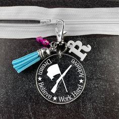 a keychain with a tassel hanging from it's side on a white zipper