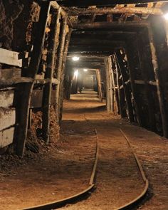 a train track going through a tunnel with light at the end