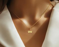 ☆ Queen Crown Necklace - Gold Plated Royal Charm Jewelry for Women elegant gold crown necklace is perfect for anyone who wants to feel like royalty. Featuring a beautiful crown design with a heart in the center, this gold plated pendant is both stylish and regal. Whether you're gifting it to a queen in your life or treating yourself to something special, this crown necklace adds a touch of royalty to any outfit. At Opiona Jewelry, we craft all our pieces with dedication and care. This handmade 925 sterling silver necklace is a special treat for yourself or a thoughtful gift for a loved one. We offer customization options, including personal names or inscriptions--feel free to message us for more details. ☆ The standard necklace length is 16" for adults and 12" for kids. ☆ Materials: 925 St Elegant Crown Pendant Jewelry, Gold Necklaces With Crown Design For Gifts, Dainty Jewelry With Crown Design For Gift, Dainty Jewelry With Crown Design As Gift, Elegant Gold Jewelry With Crown Design, Elegant Gold Crown Design Jewelry, Elegant Crown Design Necklace For Wedding, Elegant Crown Design Necklace For Gift, Crown Necklace