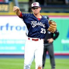 a baseball player pitching a ball on top of a field with his arm in the air