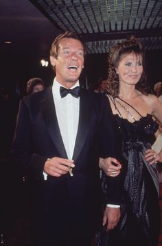 a man in a tuxedo standing next to a woman