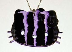 a black and purple cat necklace with two cats on it