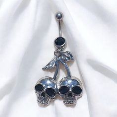 two skulls are attached to the back of a belly ring