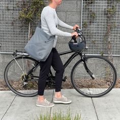 a woman riding a bike with a bag on the back