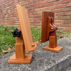 two pieces of wood sitting on top of a cement slab next to a brick wall