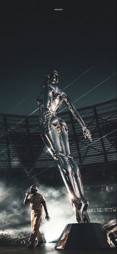 two people are standing in front of a large metal statue that looks like a human body