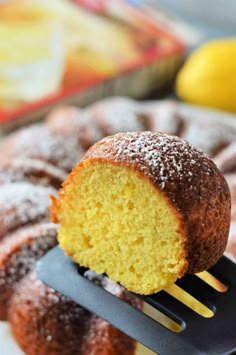 a bundt cake being held by a spatula with powdered sugar on top