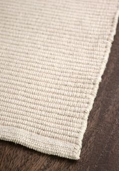 a close up view of a white rug on a wooden floor