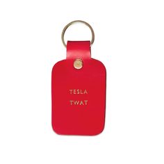 a red leather keychain with the words tesla tat on it's front