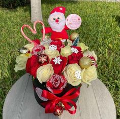 a valentine's day arrangement in a santa claus hat with candy canes and roses