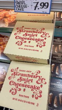 two boxes of trader joe's strawberry cheesecake are on display in a store