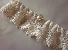 a white lace garter with pearls on it