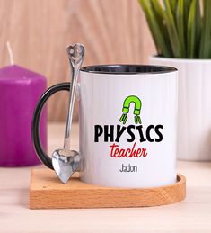 a white coffee mug with the words physics teacher on it and a spoon next to it