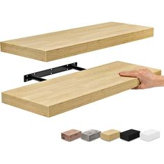 a hand is holding the edge of a wooden shelf with several different color options to choose from