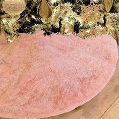 a pink rug with gold sequins and pineconis on the top is sitting on a wooden floor