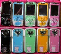 many colorful cell phones are lined up in a row on a pink display shelf with hearts