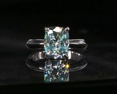 Rare Blue Green Cushion Cut Moissanite Ring - Black Diamonds New York Green Moissanite Ring, Sapphire Wedding Ring Set, Diamond Carat Size, Cushion Cut Moissanite Engagement Ring, Halo Wedding Set, Moissanite Engagement Ring Cushion Cut, Green Moissanite, Sapphire Wedding Rings, Moissanite Engagement Ring Halo