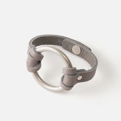 a gray leather bracelet with two circles on it