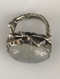 "This unusual ring has a large oval shaped cabochon moonstone that is bezel set in south-west fashion. The band looks almost like branchlike wavy lines. The silver setting which is raised to hug the stone has a hammered and pinched look and has some areas where it looks like the silver has split which is part of the design. The face of this ring is 3/4\" long and about 1\" at its widest. It shows as a size 4 1/4 on my ring sizer, but fits my size 5 finger. Please see all photos for details, as w Hand Forged Oval Moonstone Ring, Unique Moonstone Ring With Large Stone, Oval Hand Forged Moonstone Ring For Anniversary, Hand Forged Oval Moonstone Ring For Anniversary, Handmade Oval Moonstone Ring In Modern Style, Handmade Modern Oval Moonstone Ring, Hand-forged Oval Moonstone Ring For Anniversary, Modern Handmade Oval Moonstone Ring, Modern Oval Moonstone Ring With Large Stone